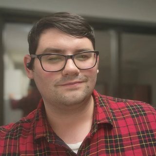 Deven, smiling, in a red plaid shirt